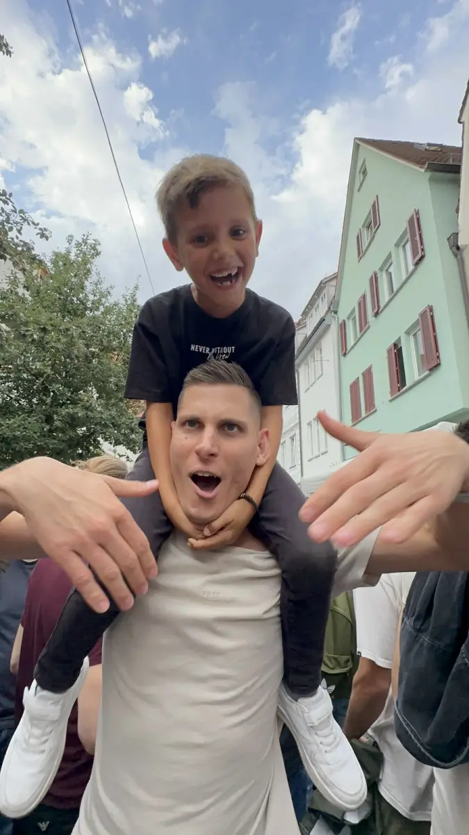 Christian Kögler mit einem lachenden Kind auf den Schultern